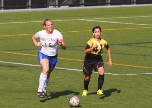 The Hofstra Woman's Club Soccer coach, Casey Personius, fills in for an injured player, making a run with the ball against Adelphi defender number 41. 