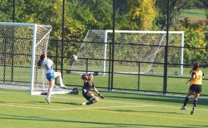Number 3, Victoria Espinoza, assists Lia, the Hofstra goalie, in kicking the ball out of bounds. 