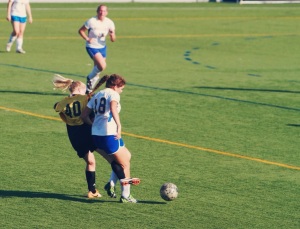 Number 18, Joanne Norris steals the ball away from Adelphi striker, number 40. 